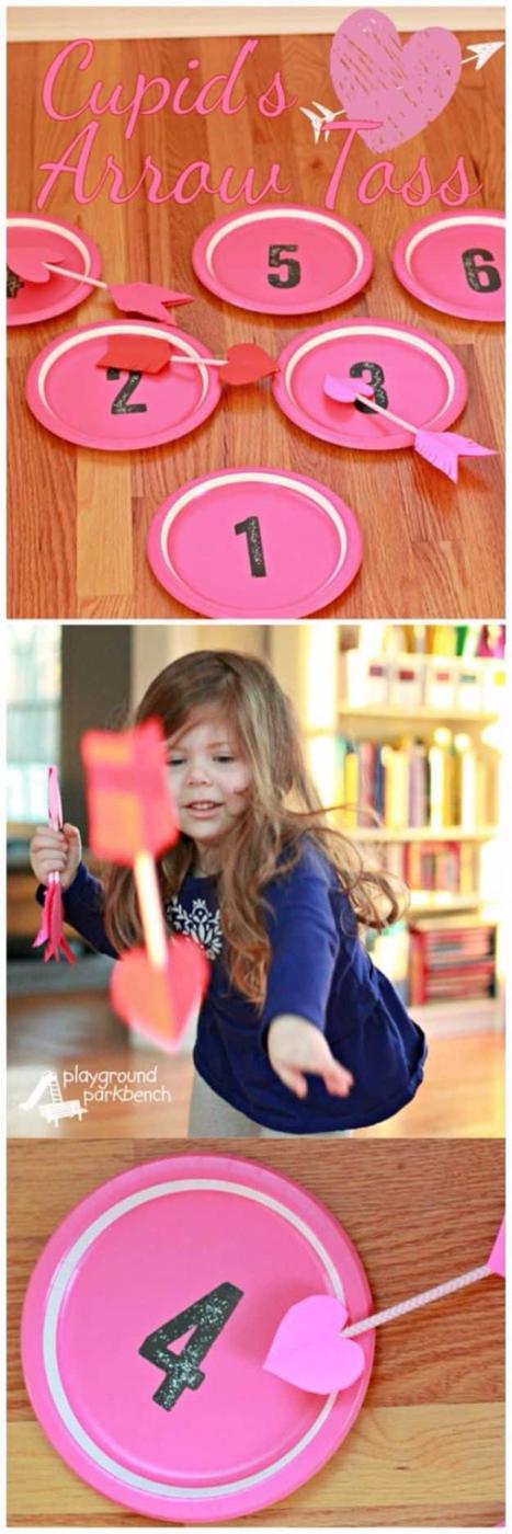 Cupid's arrow toss Valentine game with paper arrows being thrown at a large red heart target on the floor