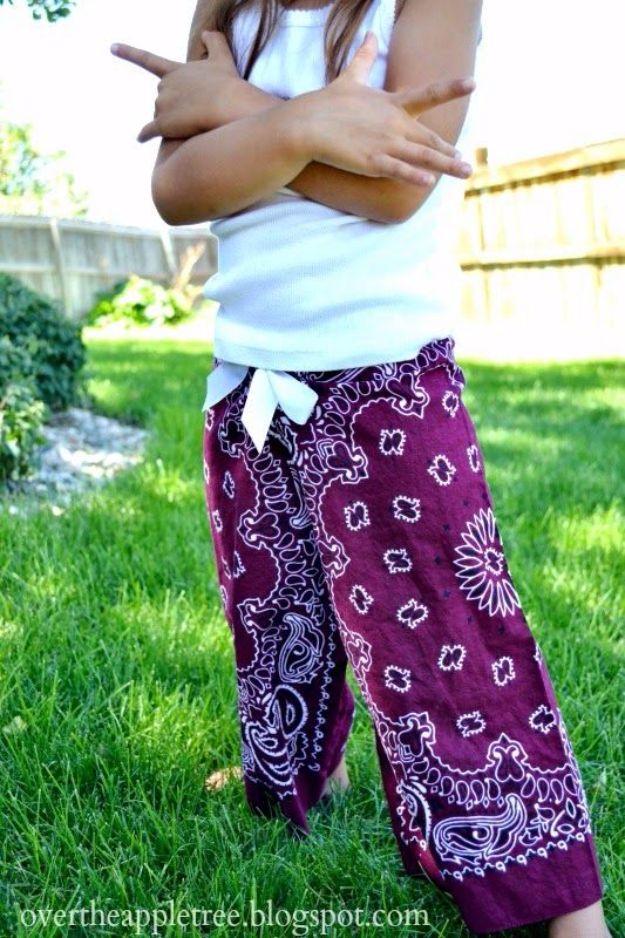 Bandana pants sewing idea, a child on grass in wide deep purple paisley bandana pants and a white tank