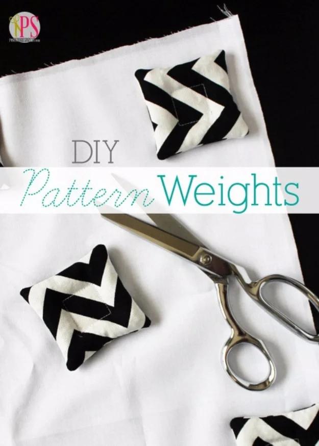 Two small black and white chevron fabric pattern weights holding white fabric flat beside steel shears