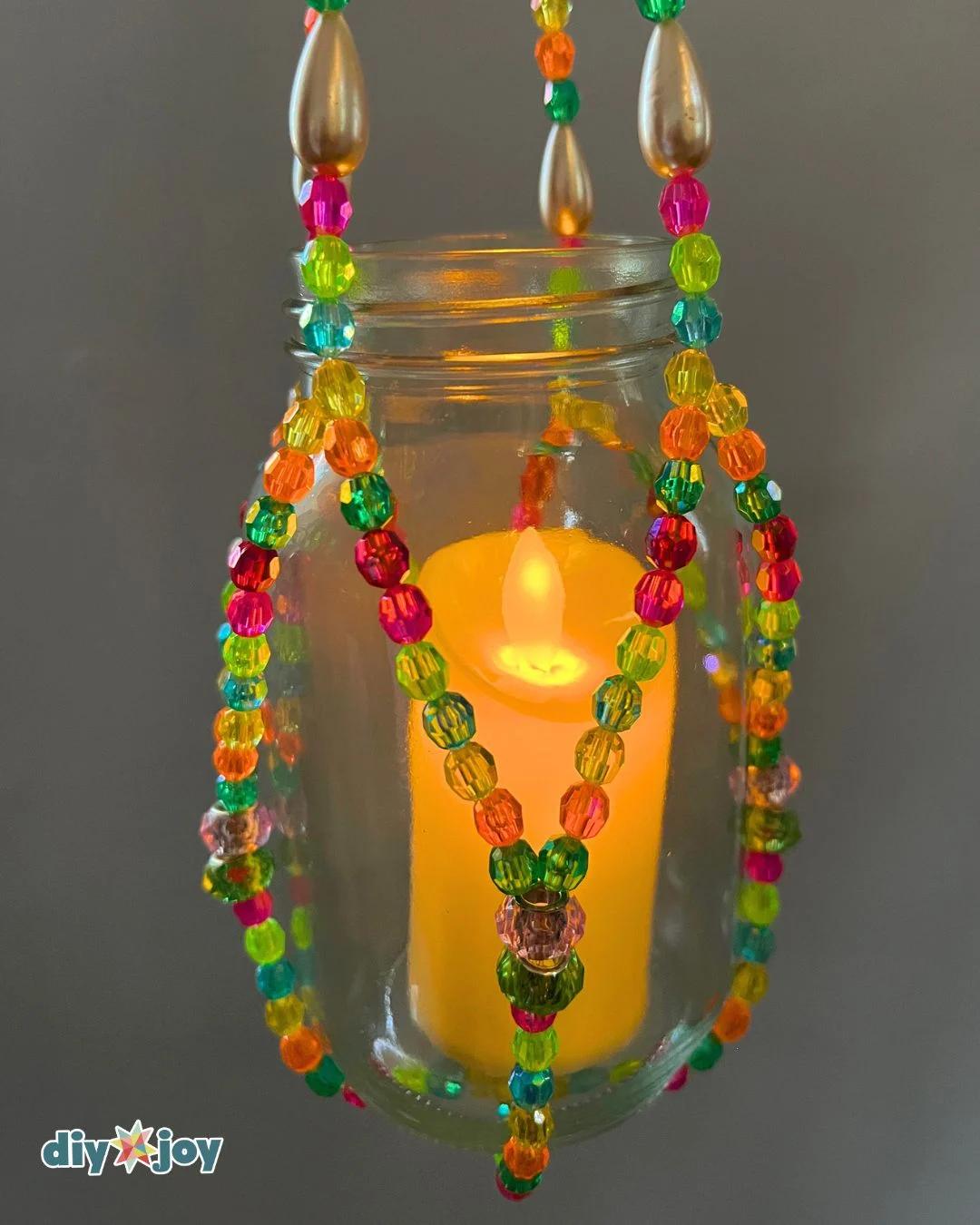 Beaded hanging lantern ideas for a porch, with a glass jar suspended inside a handmade bead and fishing line cradle