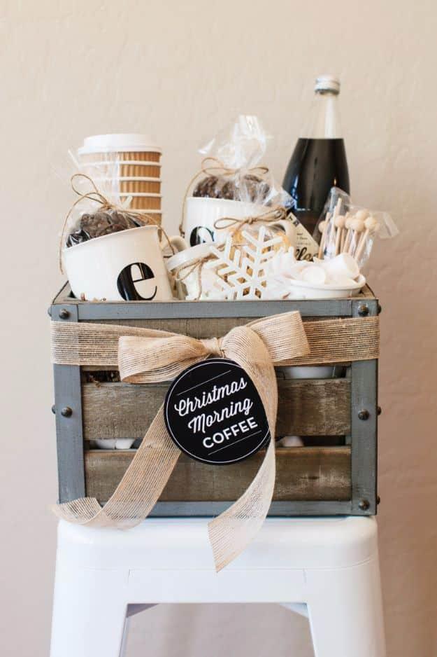 Coffee gift basket, a wooden crate filled with mugs, to go cups, coffee and treats tied with a burlap ribbon and tag