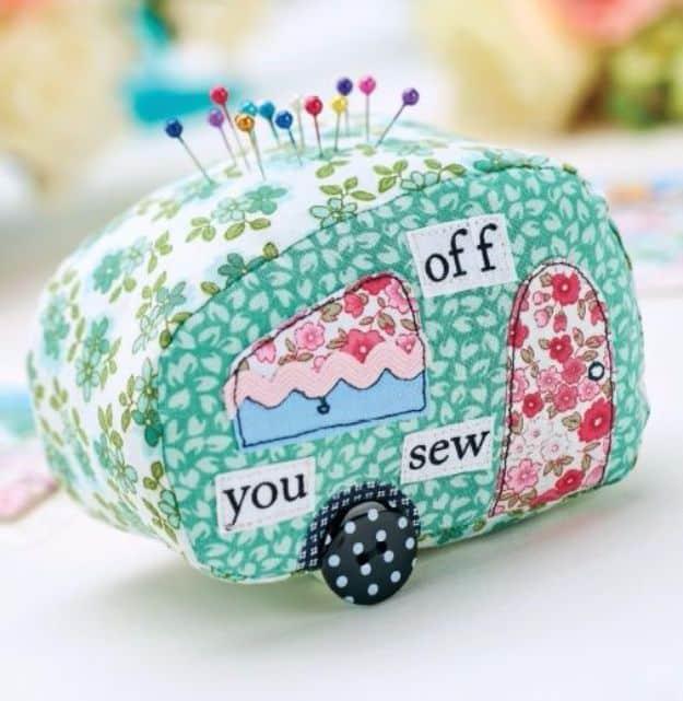 Quilting scraps caravan pincushion in green floral fabric with applique window door awning and button wheels