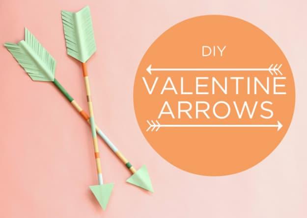 Painted wooden cupid arrows with paper fletching standing in a jar as modern Valentine's Day decor for Valentine's decorating