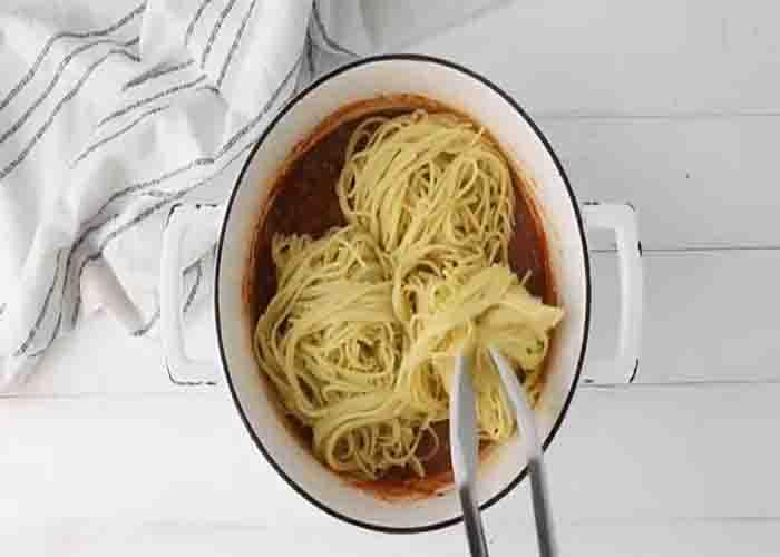 Tossing the cowboy spaghetti with its sauce