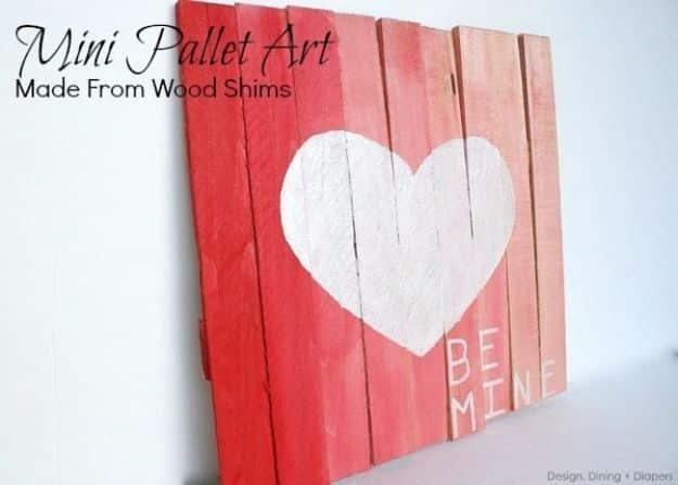 A mini wood pallet painted in ombre red with a white heart, a rustic DIY Valentine's Day decor gift idea