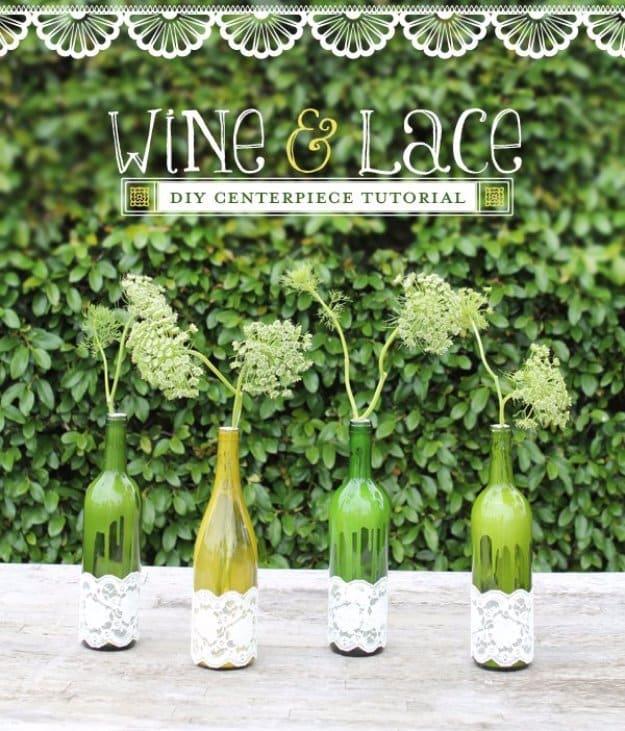 Laced wine bottle vases, green and paint dripped bottles banded with white lace, each holding a stem of Queen Anne's Lace