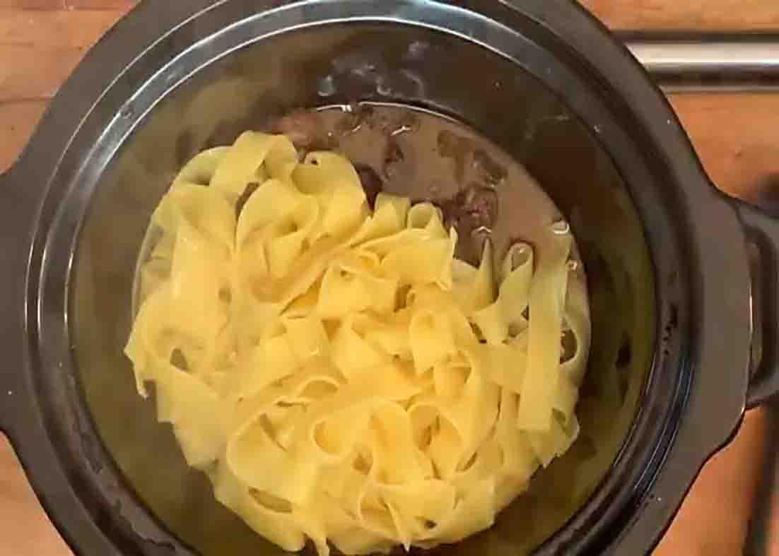 Adding the egg noodle pasta to the crockpot