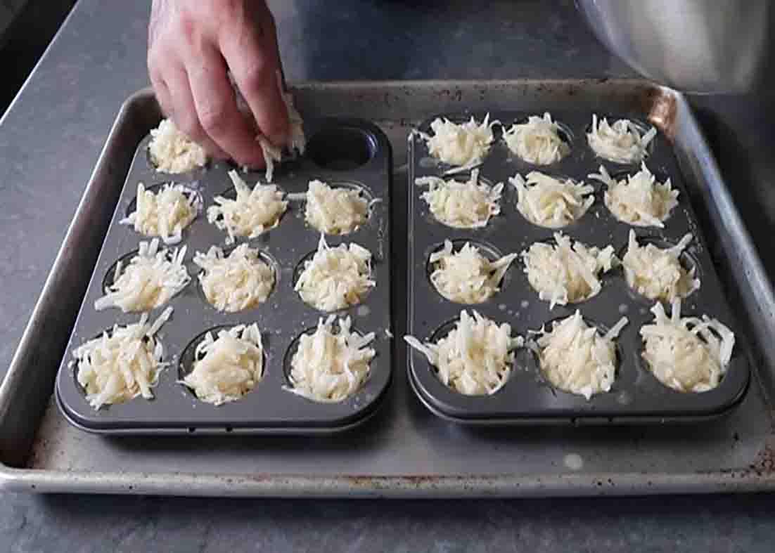 Transferring the potato poppers onto the muffin tray