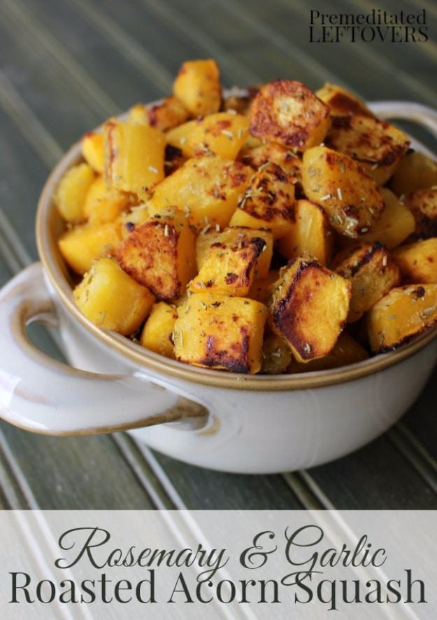 Typeset graphic titled Rosemary and Garlic Roasted Acorn Squash, browned cubes in a white dish on grey weathered wood