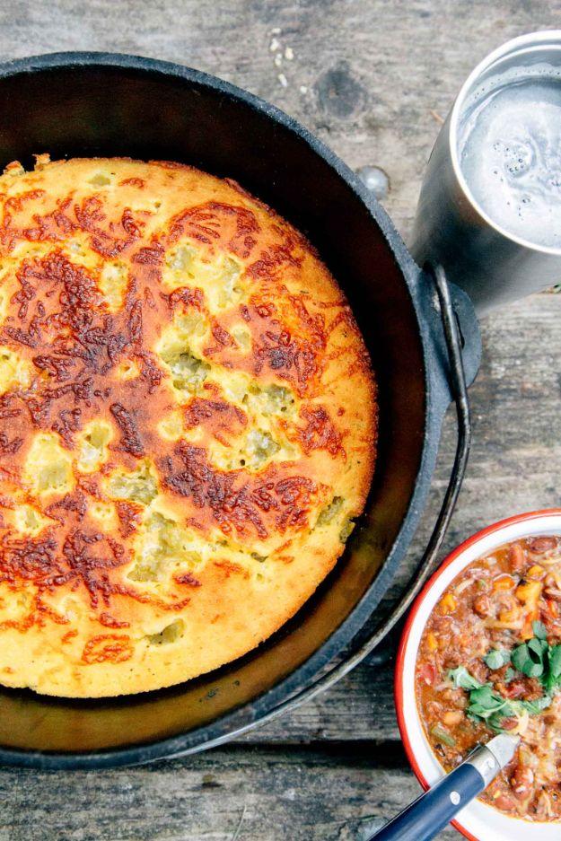 Dutch oven cornbread with green chiles and cheddar, baked over hot coals with a crisp golden edge on it