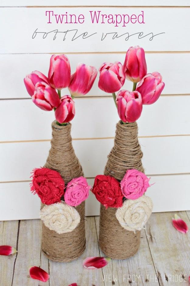 Twine wrapped bottle vases, two twine covered bottles with burlap rosettes holding pink tulips on white planks