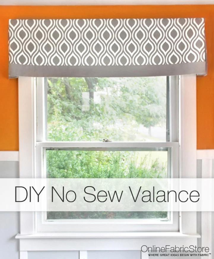 Flat grey and white ogee print valance with a solid grey lower band, mounted above a window on a bright orange wall