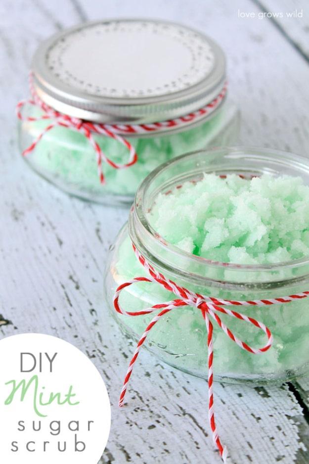 DIY mint sugar scrub in two glass jars, one lidded and one open, pale green and tied with red baker's twine