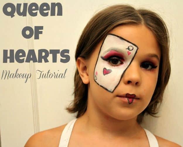 Queen of Hearts Halloween makeup with a red heart over one eye, dark drawn brows and bright red lips