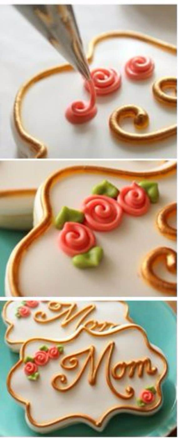 Simple royal icing roses piped in swirls onto set icing dots, with tiny green leaves piped beside them