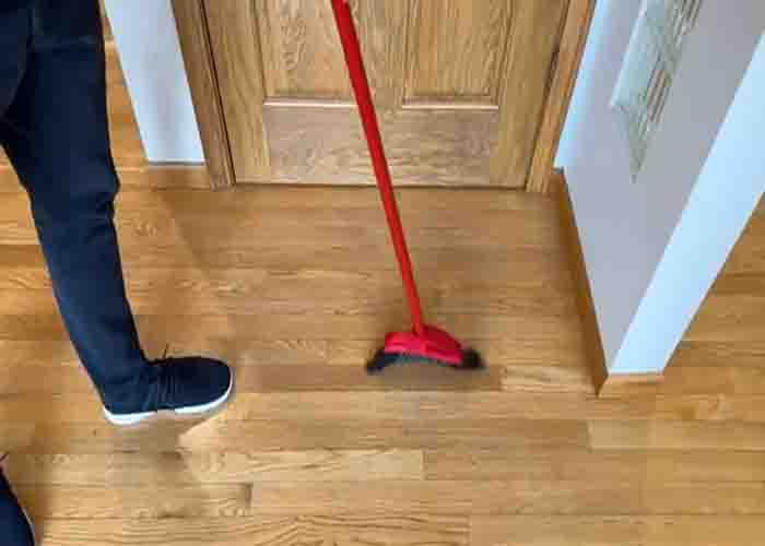 Sweeping the wood floor first before mopping