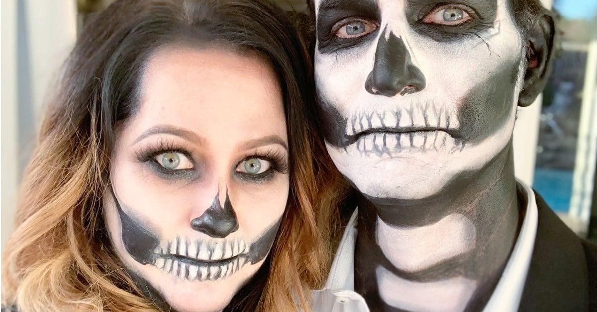 Skeleton couple Halloween makeup with black eye sockets, painted teeth, white bases and matching black outfits