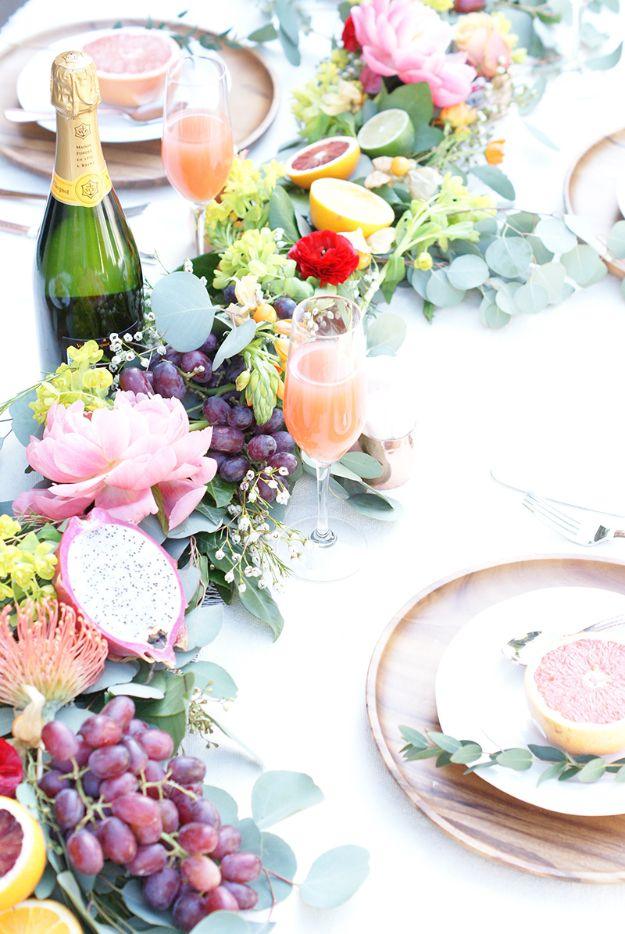 Table garland of eucalyptus and flowers with halved grapefruit, grapes and dragon fruit tucked along a runner