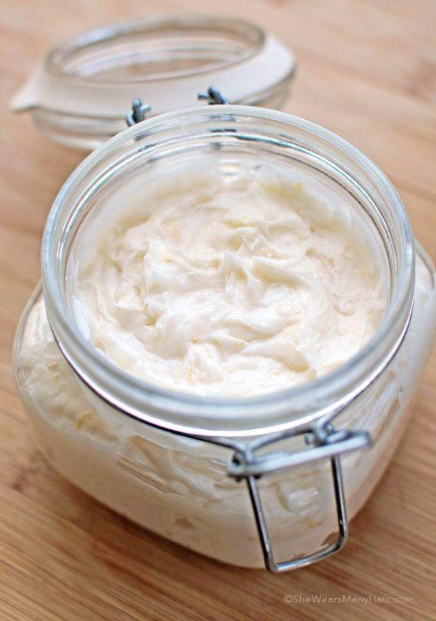 Homemade body butter, a glass clamp top jar filled with thick whipped white body butter on a wooden board