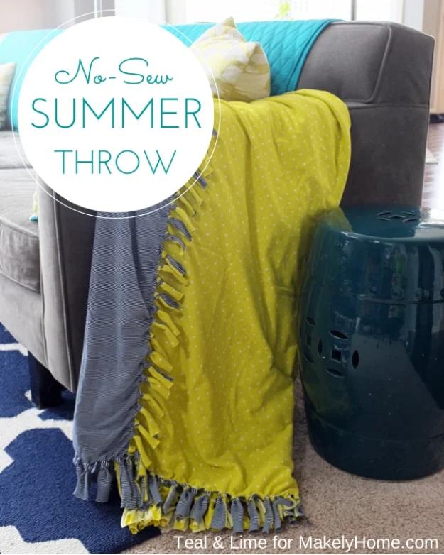 Chartreuse and gray colorblocked fleece throw with knotted fringe leaning against a sofa beside a teal stool