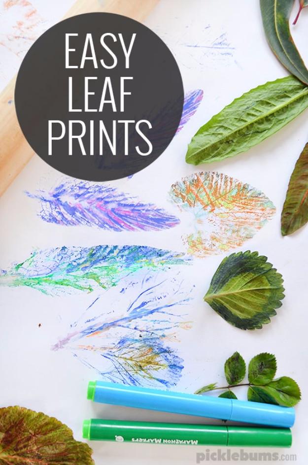 Easy leaf printing, colorful marker prints of leaves on white paper surrounded by real green leaves and two chunky markers