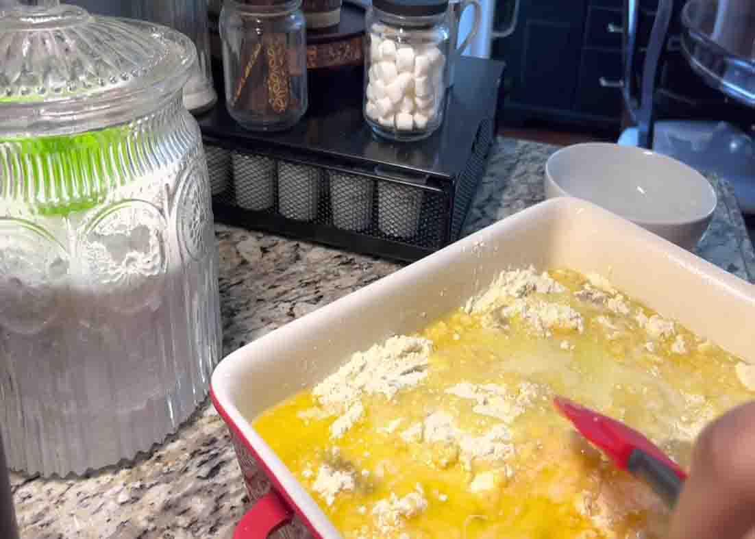 Adding the melted butter to finish up the apple dump cak