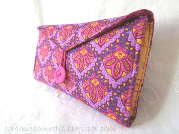 DIY fabric wallet, a purple and yellow patterned clutch wallet with a pointed flap and pink button closure