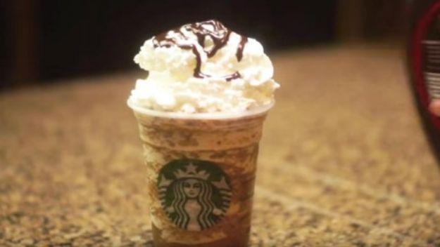 DIY Starbucks copycat frappuccino in a branded cup topped with whipped cream and a chocolate syrup drizzle