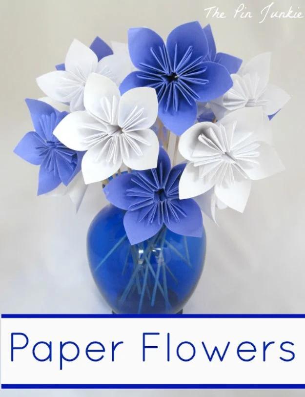 Graphic titled Paper Flowers over blue and white folded paper blooms on skewers in a cobalt glass vase on pale grey