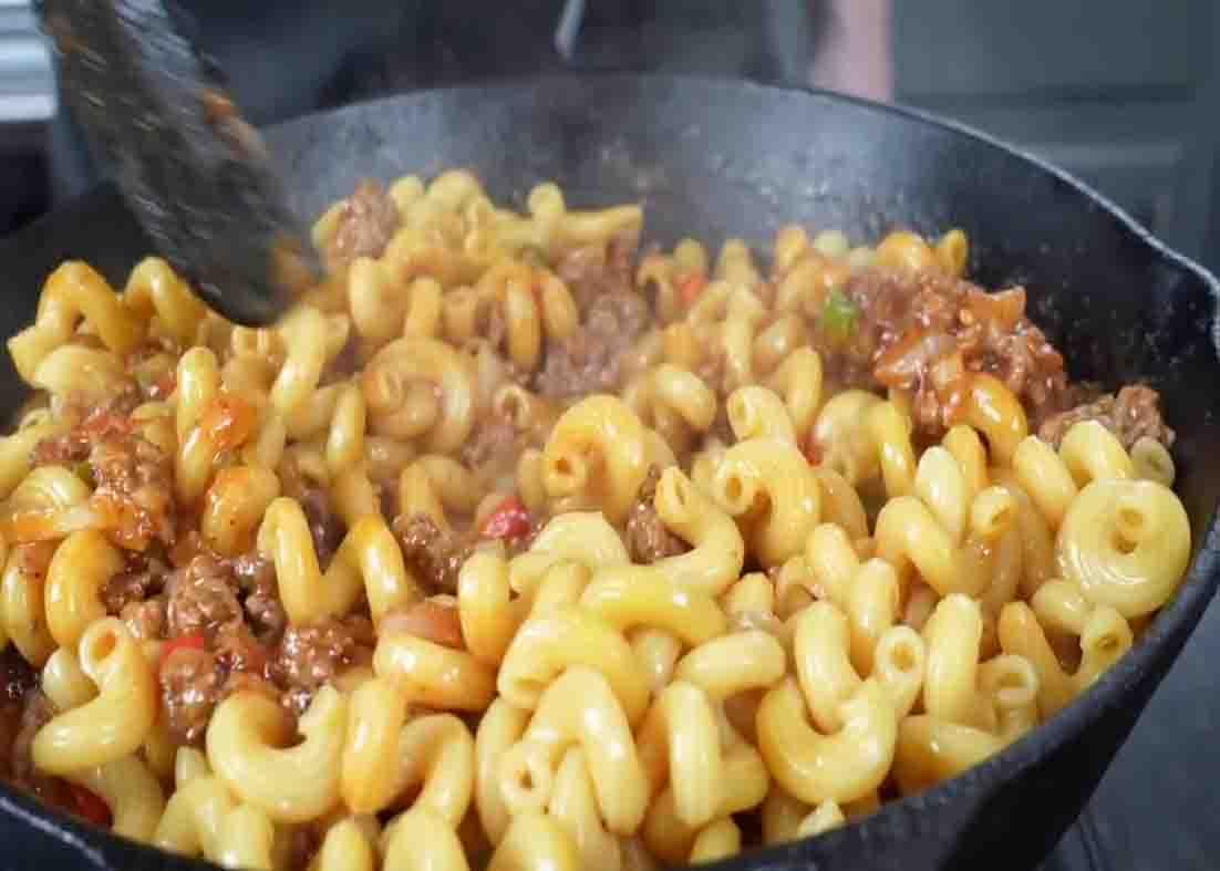Mixing the cheeseburger casserole to combine all ingredients