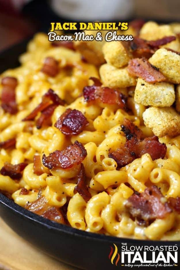 Typeset graphic reading Jack Daniel's Bacon Mac and Cheese over a skillet of macaroni with bacon and croutons