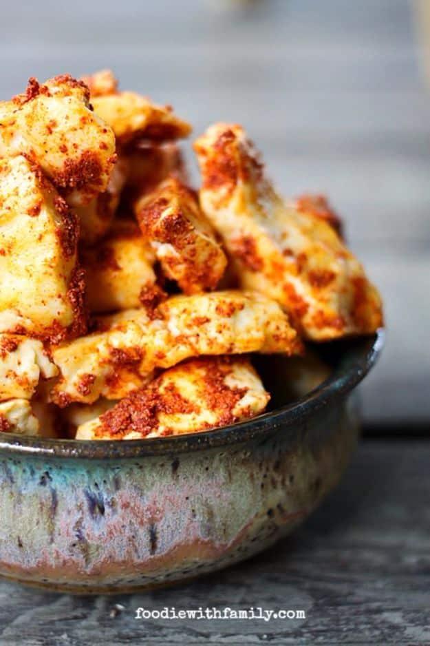 Cool ranch Dorito cheese curds tossed in red orange ranch seasoning, piled high in a glazed pottery bowl