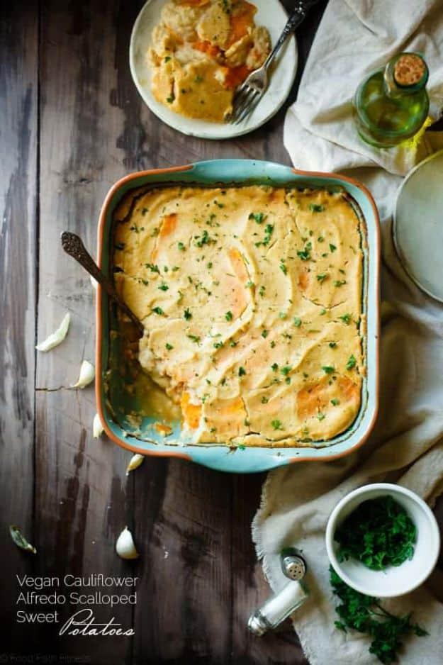 Vegan scalloped sweet potatoes layered with creamy white cauliflower alfredo sauce and topped with parsley