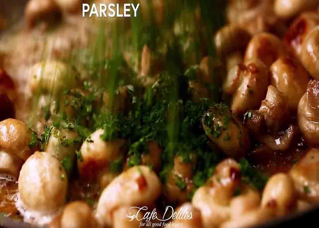 Adding parsley to the butter garlic mushrooms