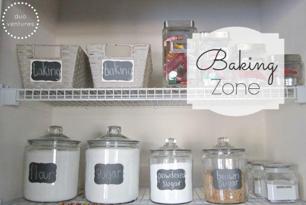 Baking shelf with chalkboard labeled glass canisters of flour, sugar, powdered sugar and brown sugar, white baskets