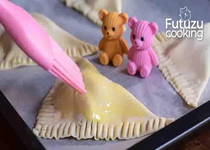 Brushing the peach turnovers with eggwash