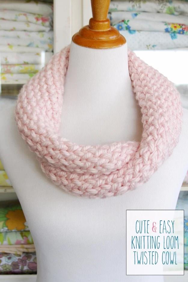 Pale pink chunky loom knit twisted cowl draped on a white dress form in front of a floral curtained window