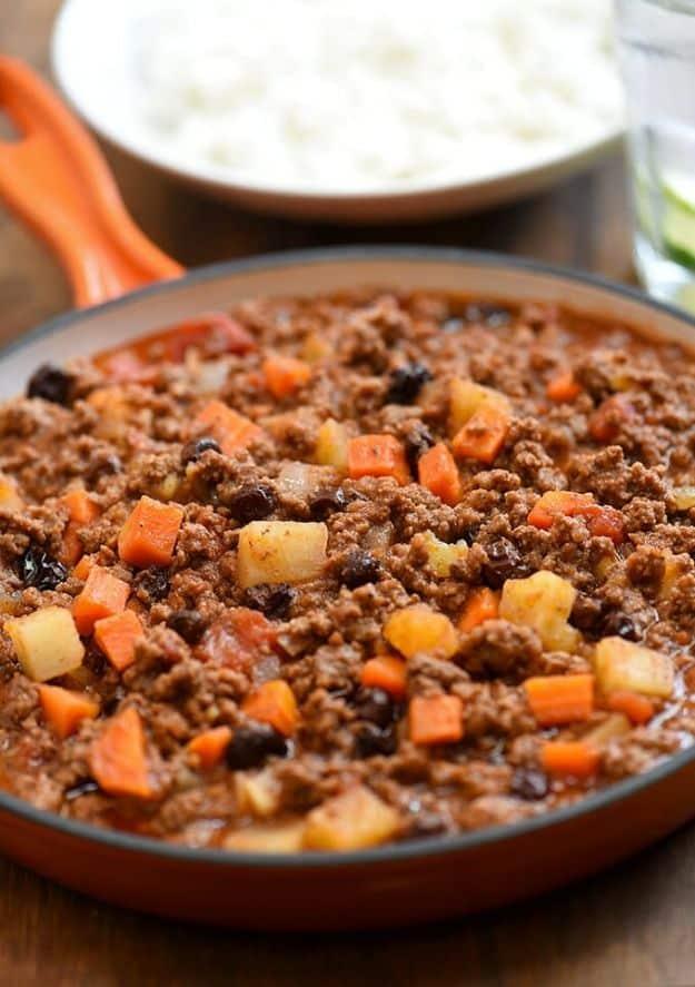 Filipino picadillo with ground beef, cubed potatoes and tomatoes served in a bowl alongside steamed rice