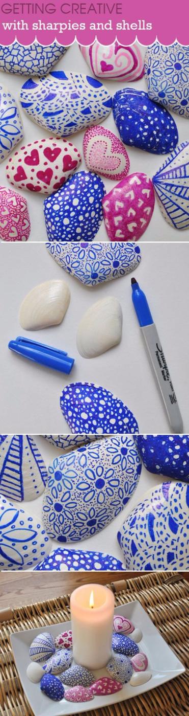 Sharpies and shells craft collage, smooth white shells doodled in blue and pink patterns beside a lit candle display