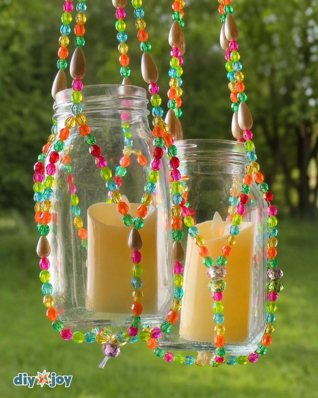 A finished DIY beaded lantern made from glass beads and fishing line with a lit candle jar glowing inside it