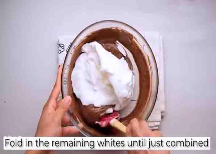 Combining the beaten egg whites and chocolate mixture to make the chocolate souffle
