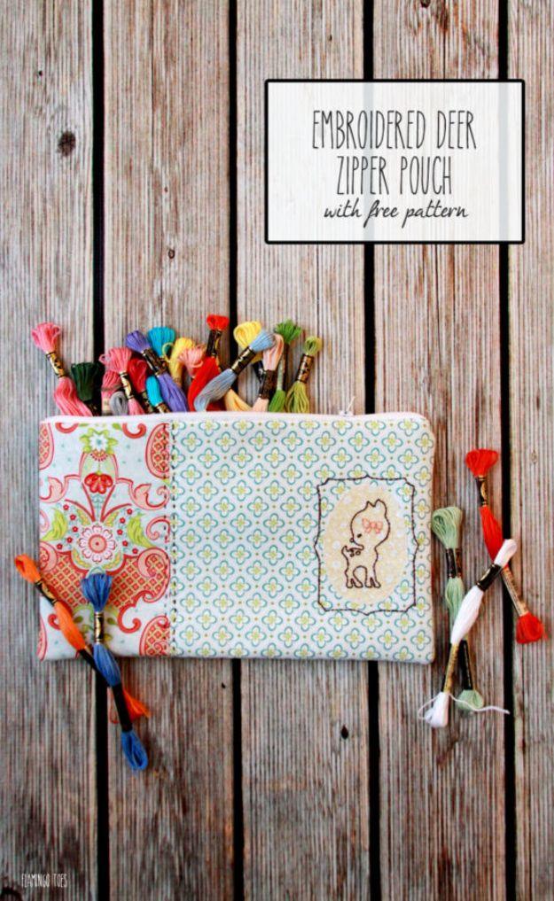 Zipper pouch with an embroidered deer on a stitched rectangular patch, on weathered wood with embroidery floss