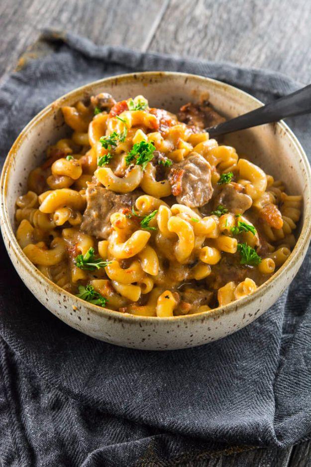 Slow cooker beer mac and cheese in a stoneware bowl, elbow macaroni with beef in a thick creamy sauce