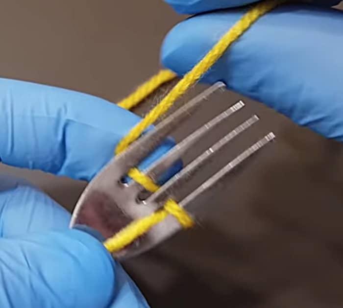 Make a yarn flower out of yarn and a fork