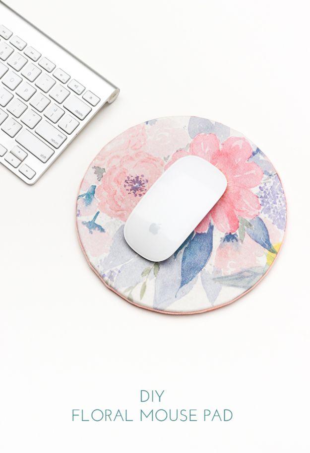 A round mouse pad covered in a blue and white floral print, sitting on a light wood desk beside a keyboard and a mug