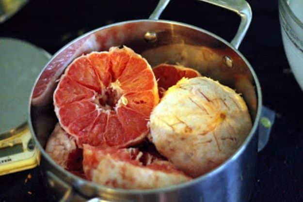 Grapefruit American pale ale in a glass, hazy orange gold, with grapefruit halves and zest beside it