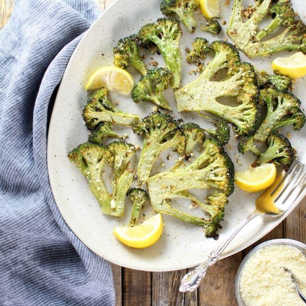 Roasted ranch broccoli steaks on a speckled platter with lemon wedges, browned at the edges and dusted with parmesan
