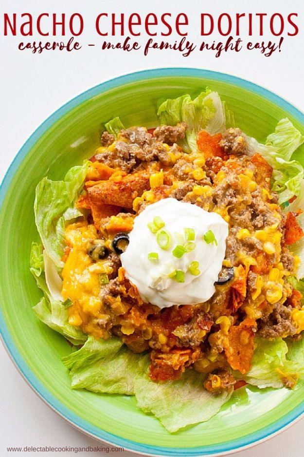 Nacho cheese Doritos casserole served over iceberg lettuce with sour cream and olives on a green plate