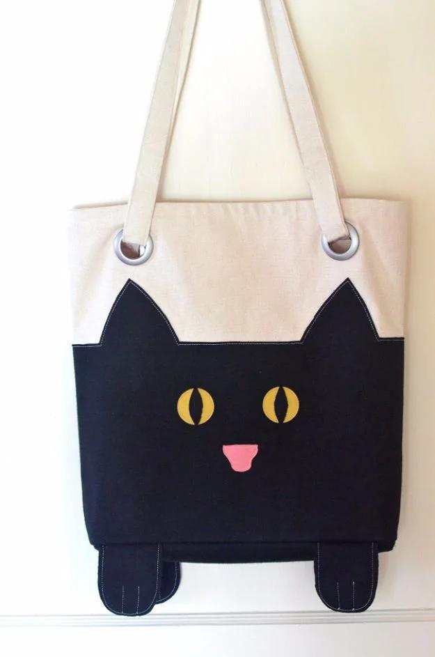 DIY cat tote bag, a cream canvas tote with a black cat face in yellow eyes and four stuffed paws hanging underneath