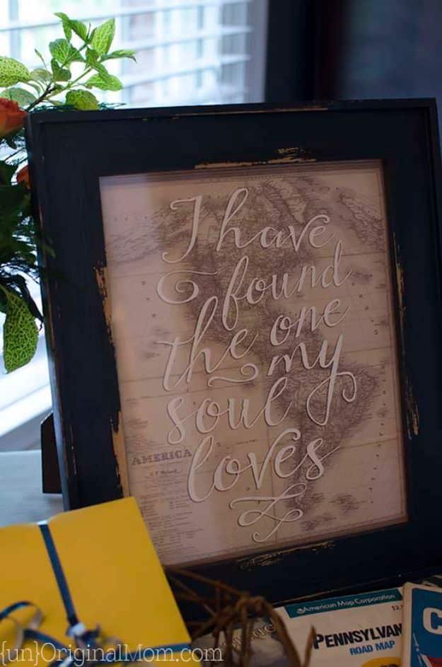 Free printable travel quotes, a hand lettered quote over a vintage road map in a dark distressed wood frame on a desk
